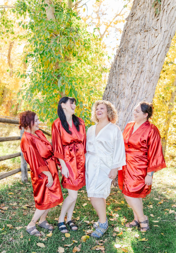 Bride and bridesmaids laughing at each other 