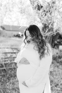 A mom holding her pregnant belly in black and white in lamoille 