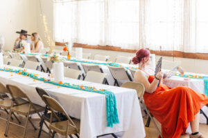 An Elko NV venue where a girl sits on a chair fanning herself. 